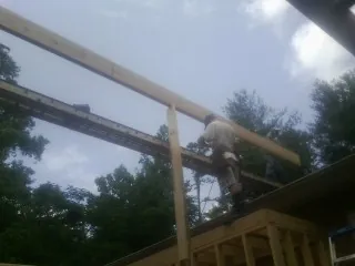 Carpenter setting a ridge beam over a new addition frame — Ice Dam Removal by Roofing Brothers in Yale