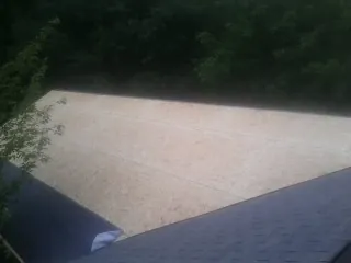 New OSB roof sheathing installed beside an existing shingle roof in Yale