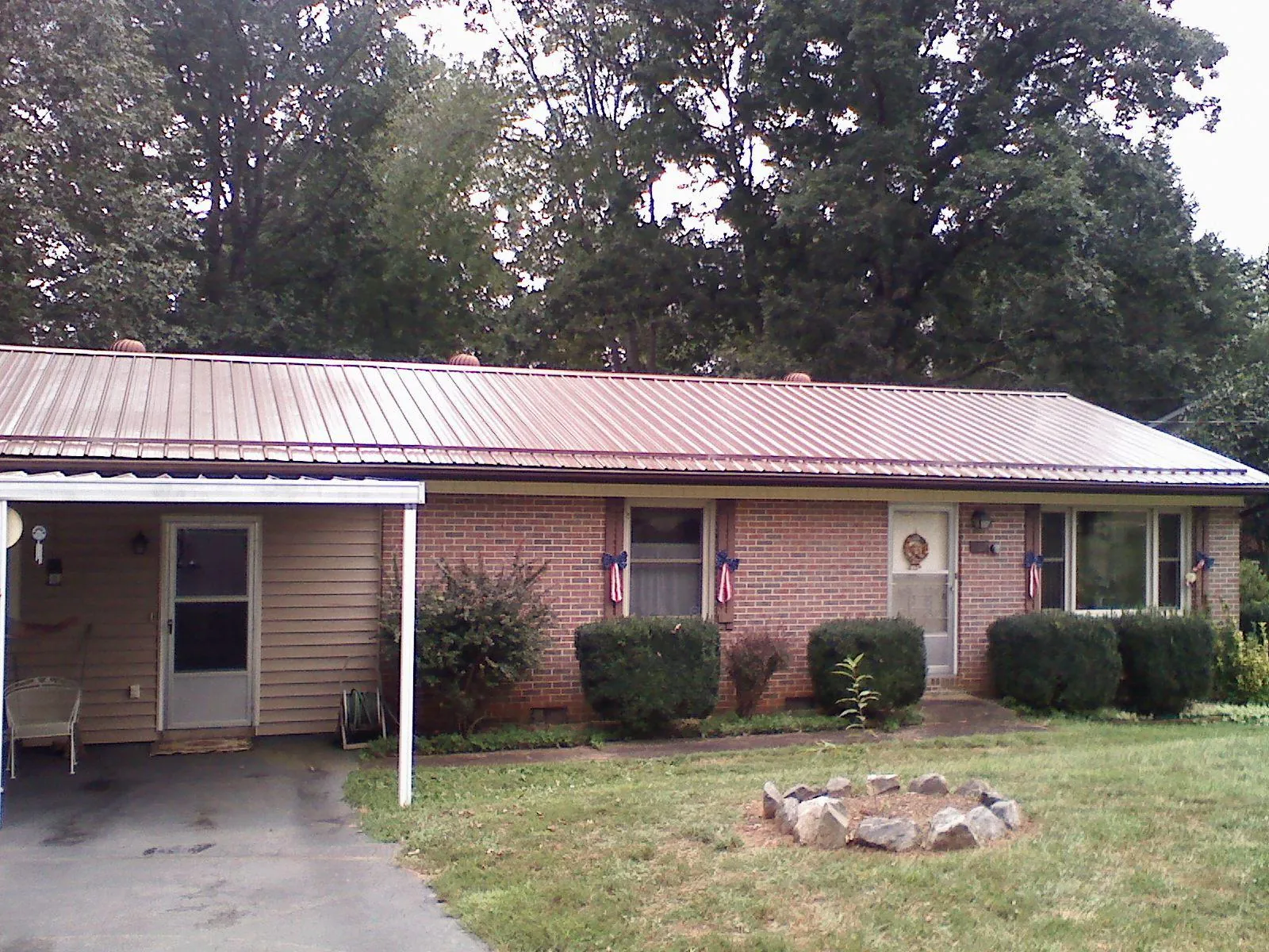 Bronze metal roof and carport on a brick ranch home — Roof Repair work by our crew in Yale